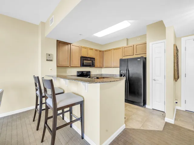 a kitchen with granite countertop white cabinets stainless steel appliances and a sink