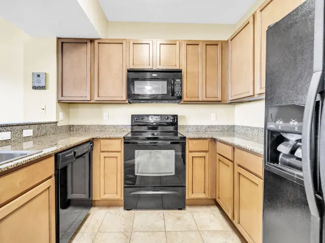 a kitchen with stainless steel appliances granite countertop a refrigerator and a stove top oven