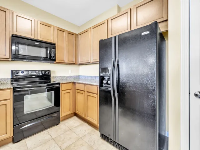 a kitchen with granite countertop a sink stainless steel appliances white cabinets and a granite counter tops