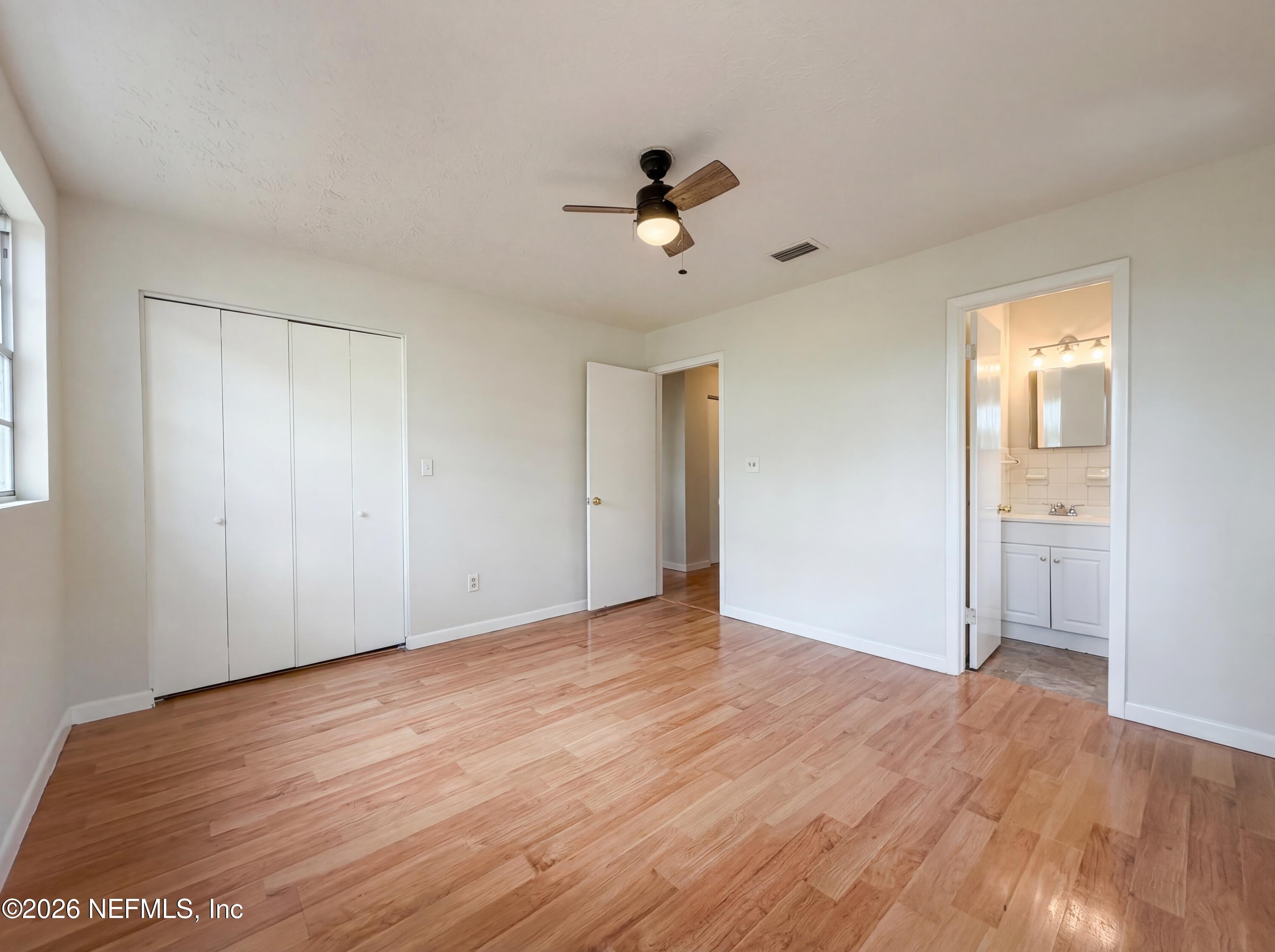 6917 Gatorbone Road Keystone Heights, FL 32656 - Photo 12 of 24 a view of an empty room with wooden floor and a ceiling fan