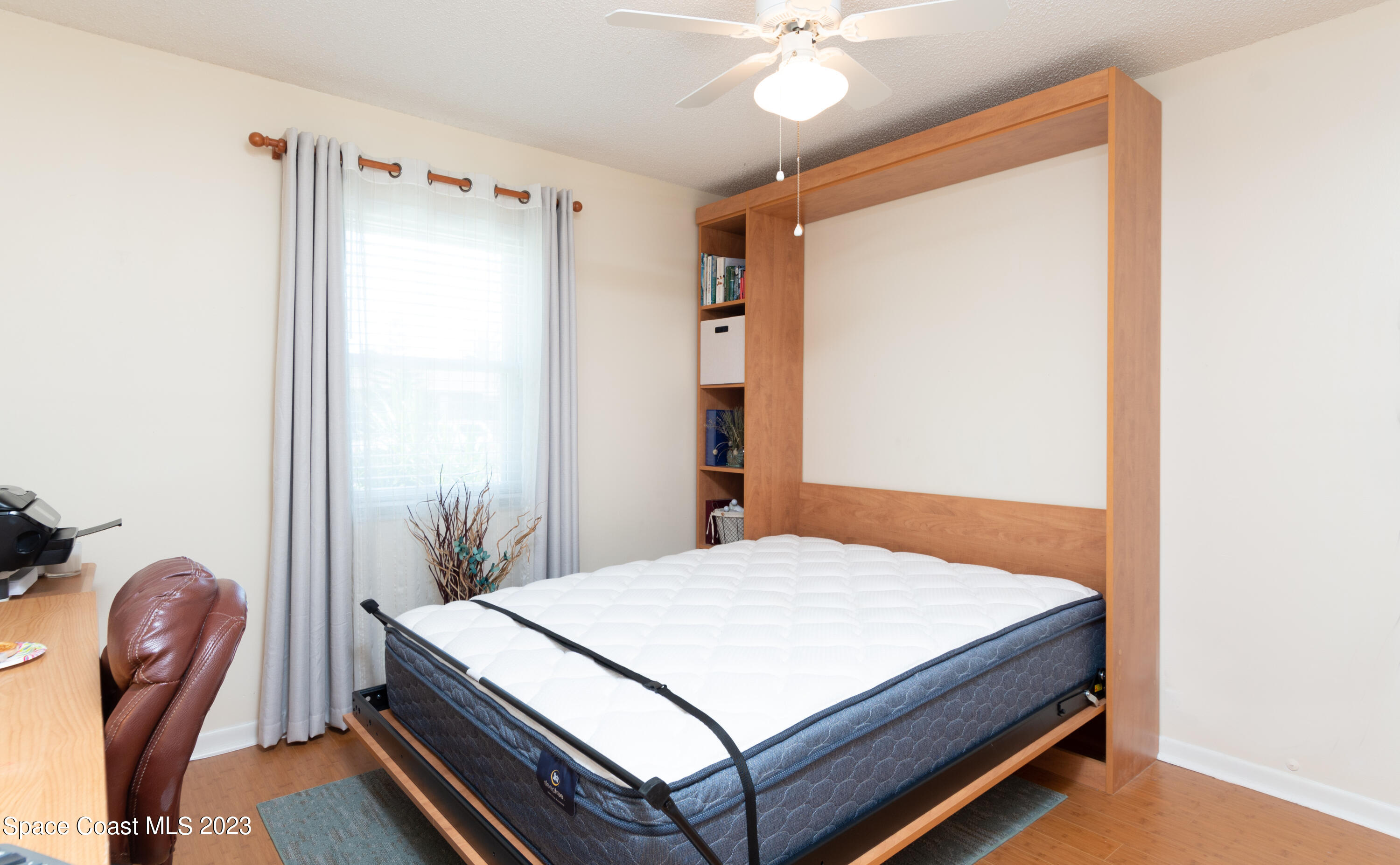 1919 Player Circle North Melbourne, FL 32935 - Photo 13 of 29 a bedroom with a bed and a chandelier