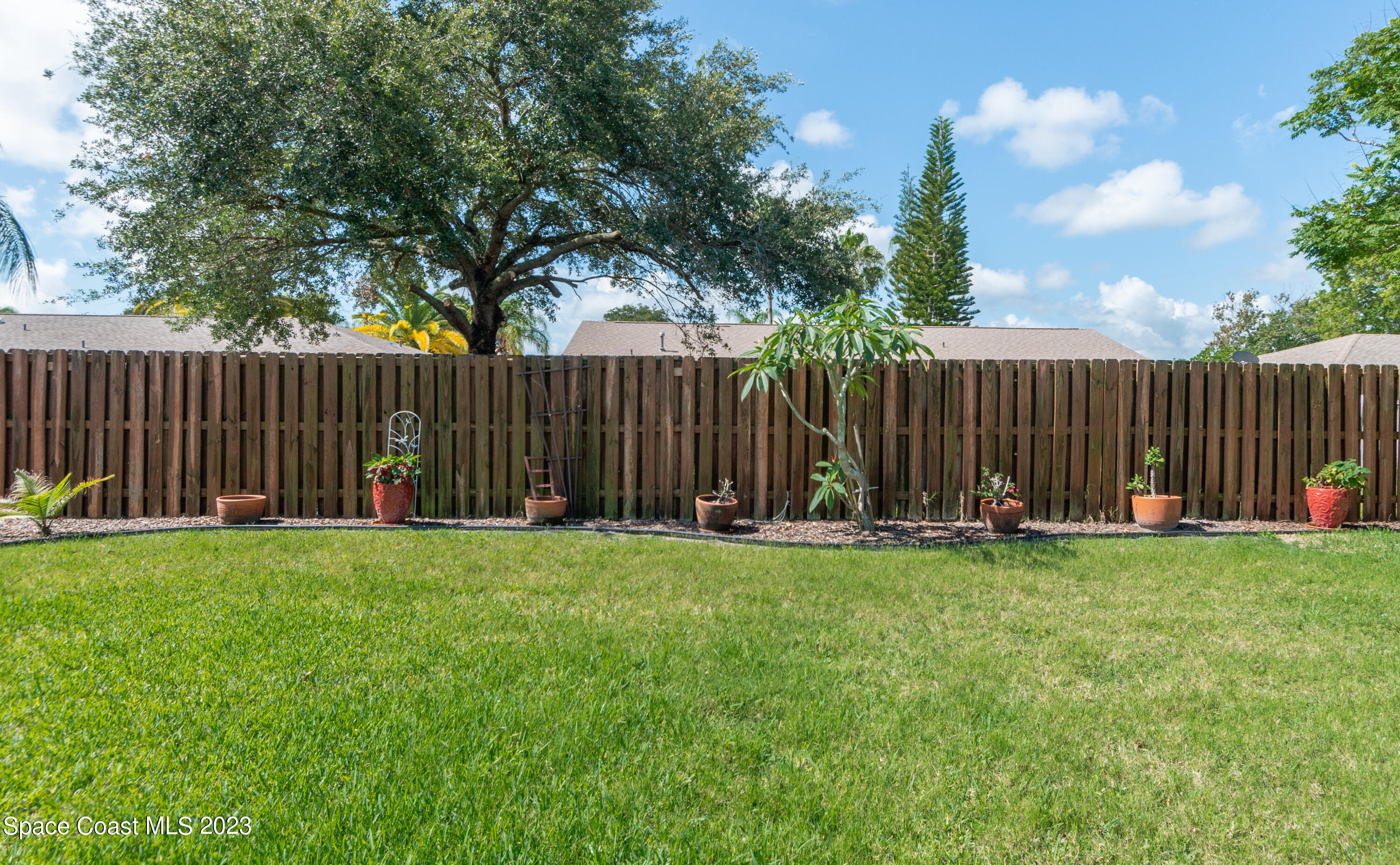 1919 Player Circle North Melbourne, FL 32935 - Photo 21 of 29 a view of a garden with wooden fence