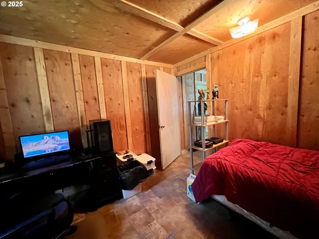 a bedroom with a bed and a flat tv screen