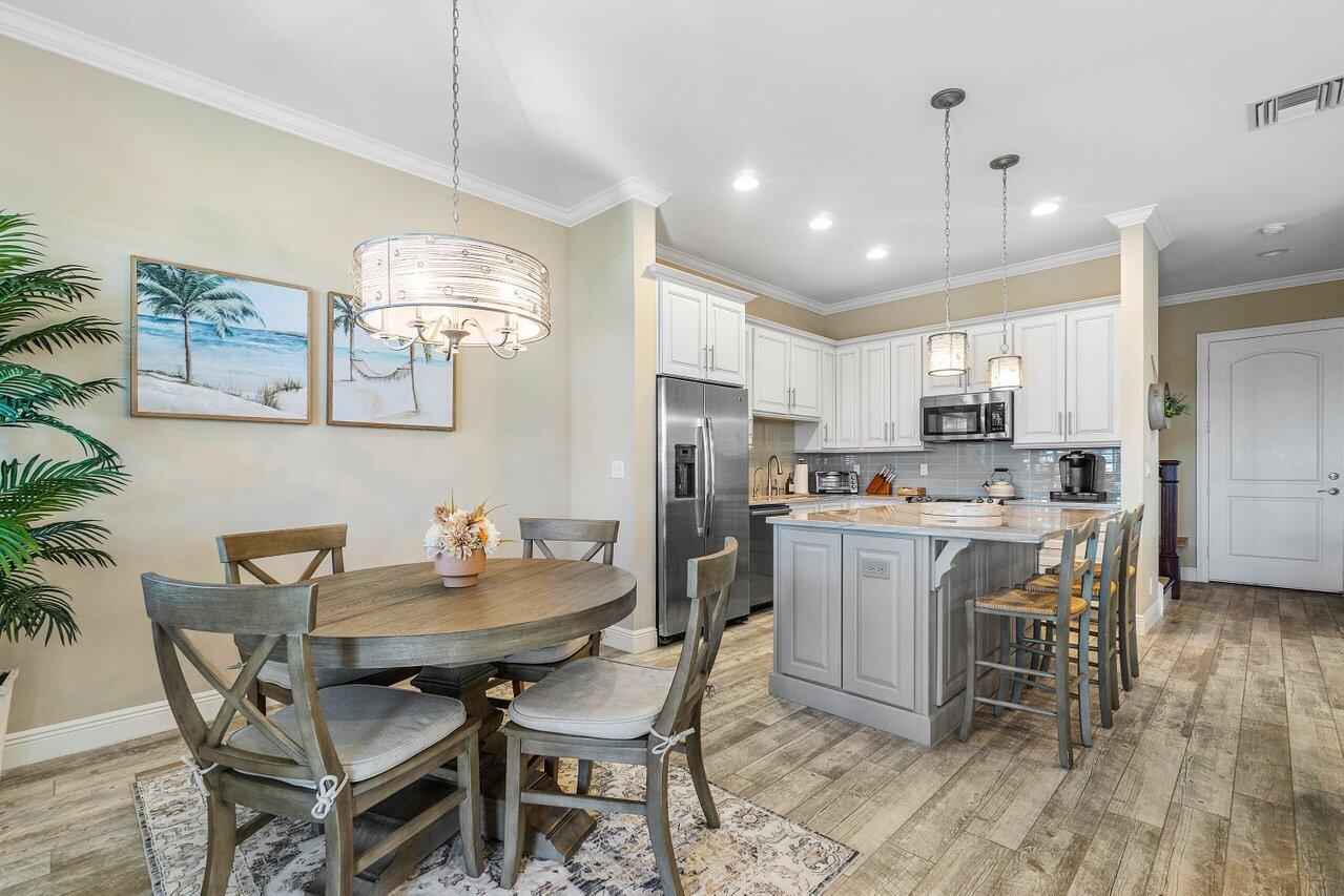 136 Ocean Breeze Drive Juno Beach, FL 33408 - Photo 12 of 30 a kitchen with kitchen island a dining table and chairs