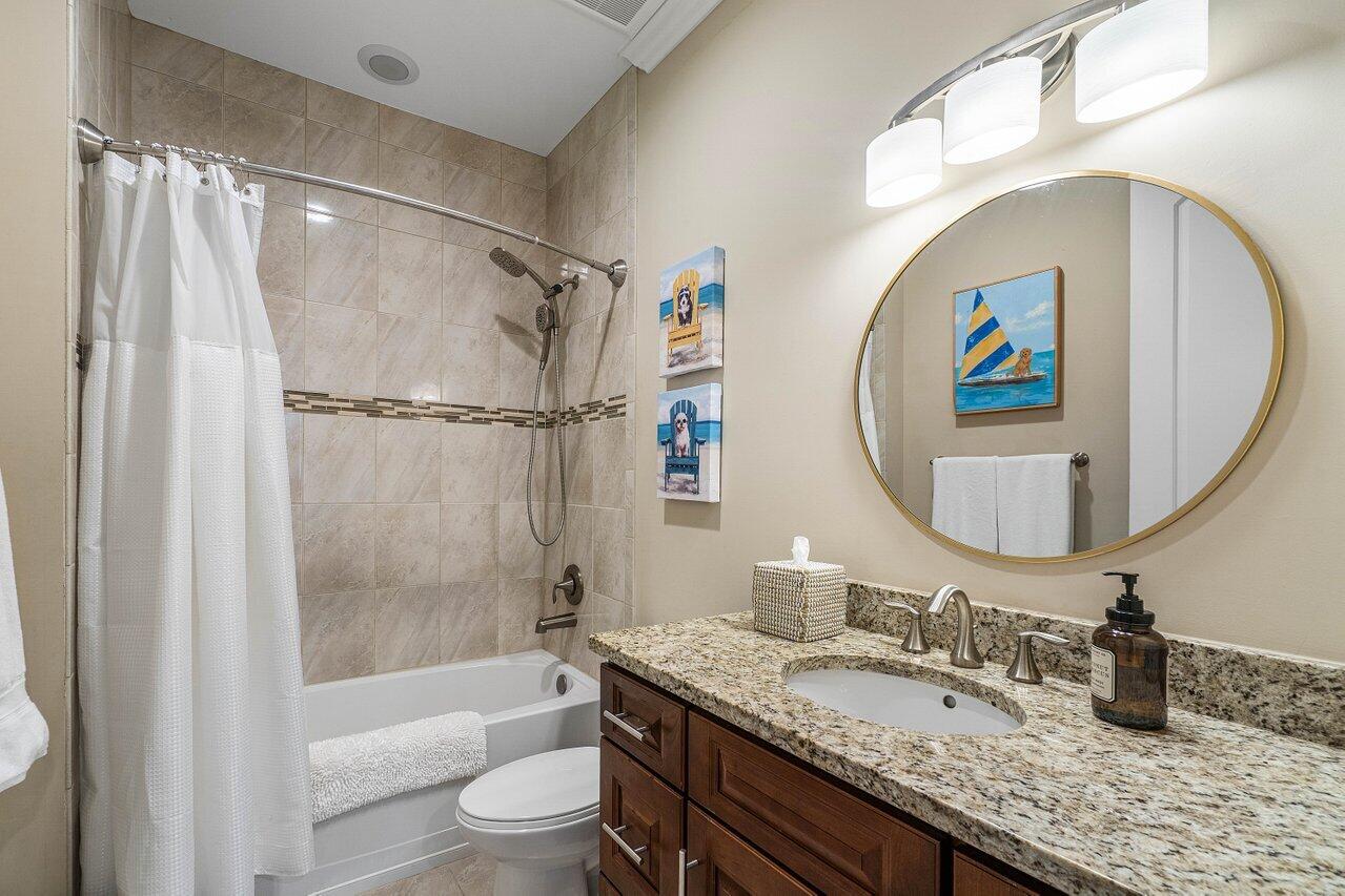 136 Ocean Breeze Drive Juno Beach, FL 33408 - Photo 20 of 30 a bathroom with a granite countertop sink mirror toilet and bathtub