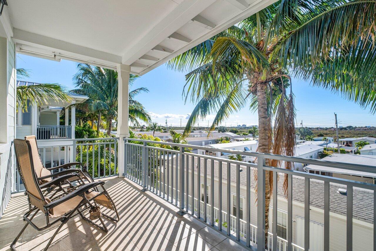 136 Ocean Breeze Drive Juno Beach, FL 33408 - Photo 27 of 30 a view of a chair and tables in the balcony