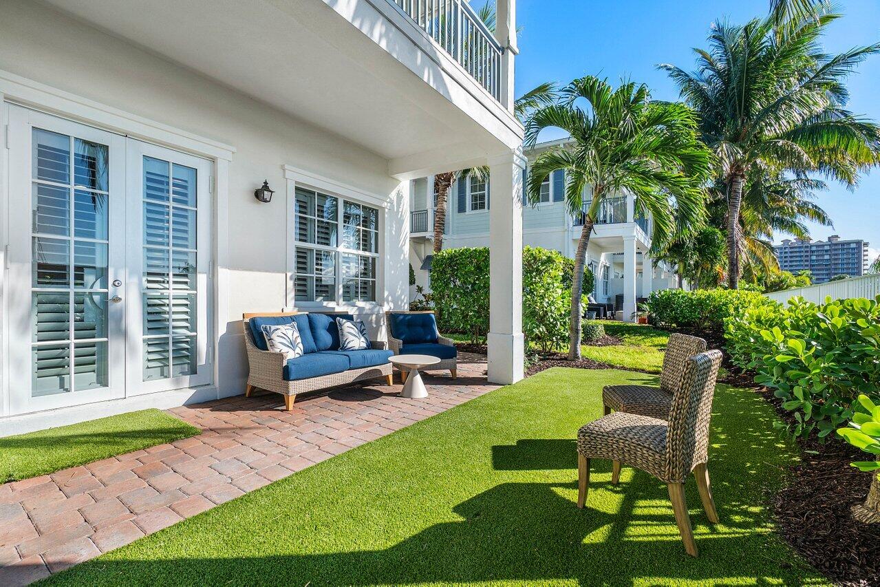 136 Ocean Breeze Drive Juno Beach, FL 33408 - Photo 3 of 30 a view of a house with backyard sitting area and garden