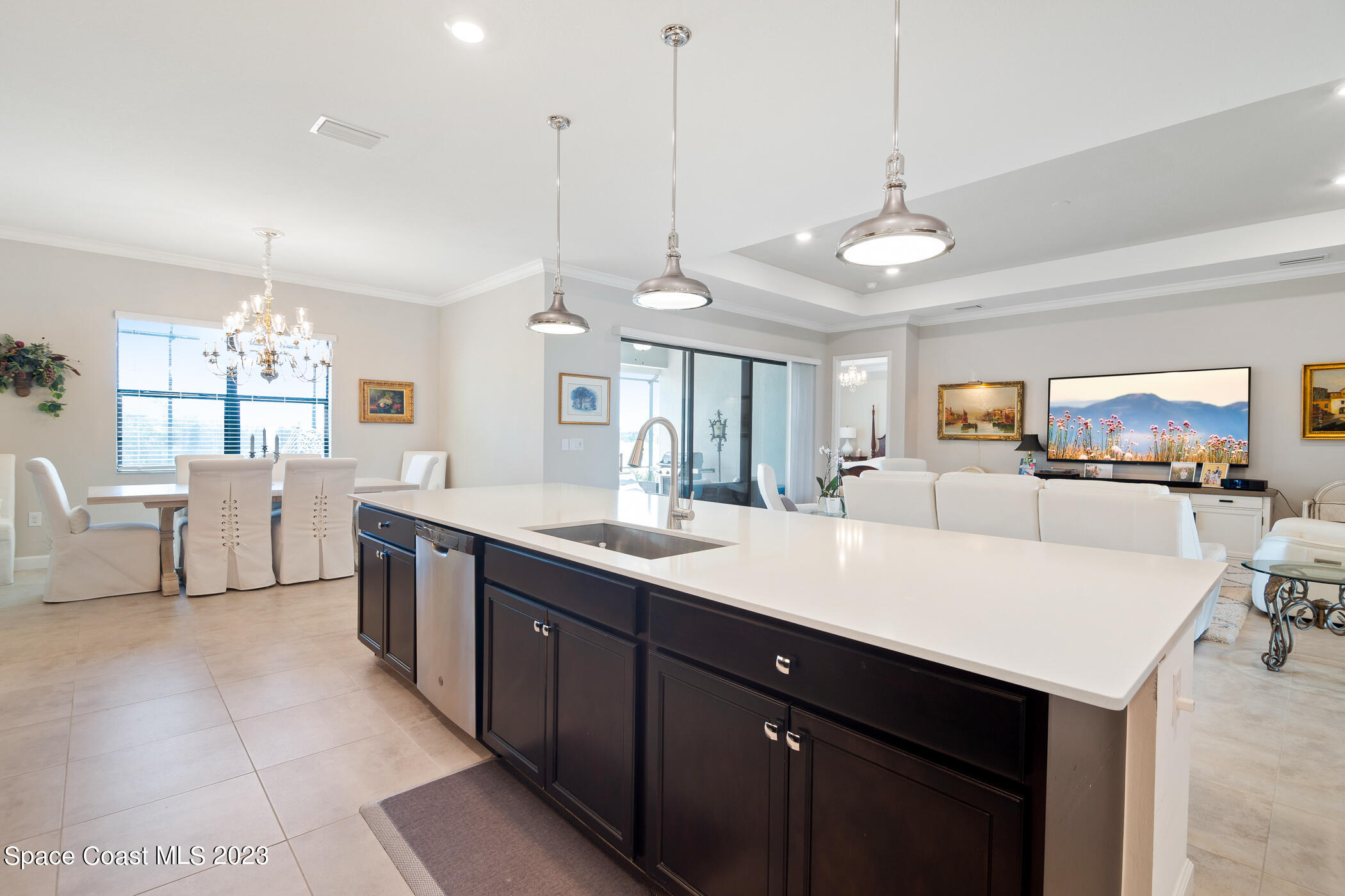 2579 Millennium Circle Melbourne, FL 32940 - Photo 18 of 42 a large kitchen with lots of counter space a sink appliances and a living room view