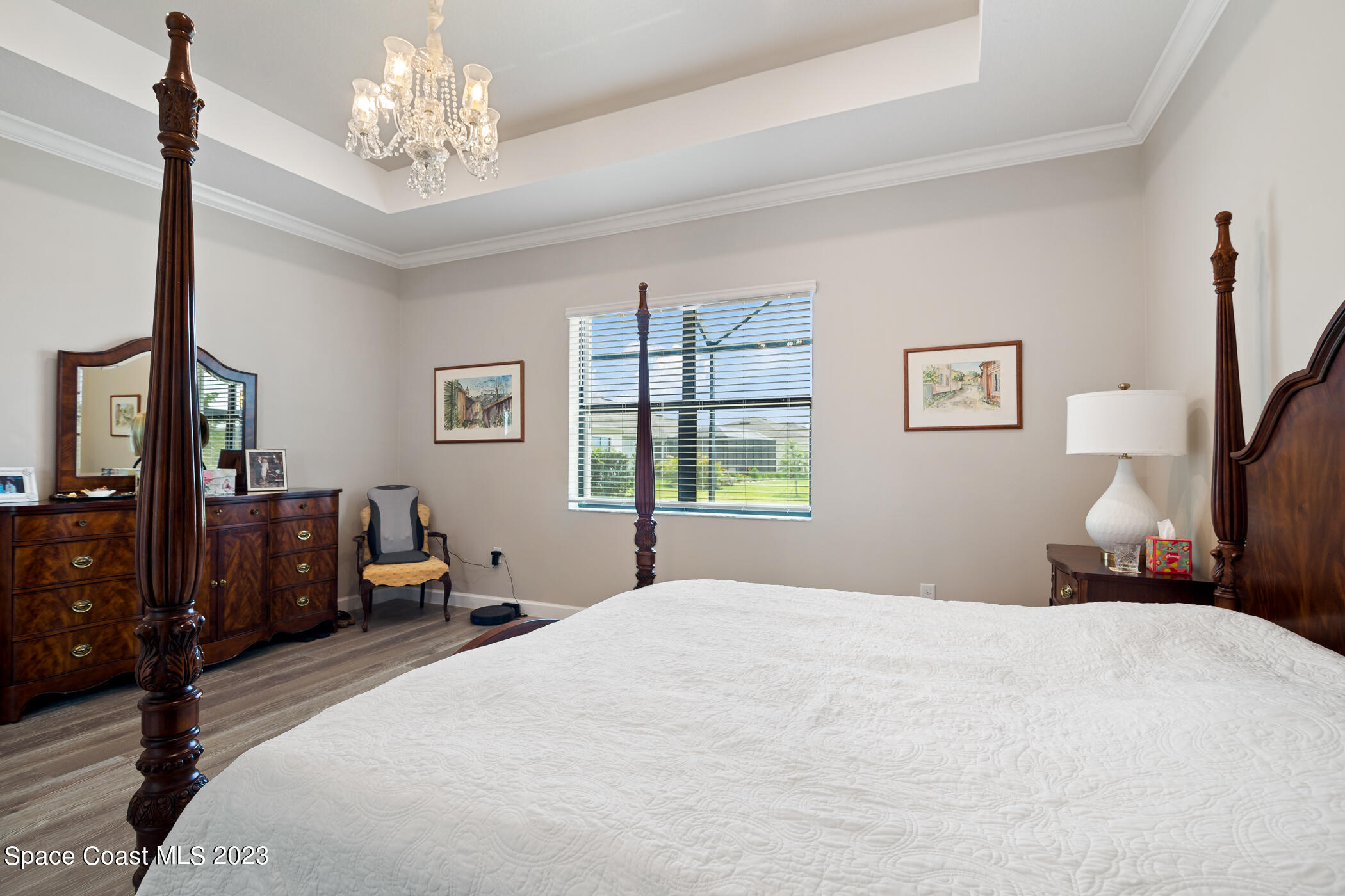 2579 Millennium Circle Melbourne, FL 32940 - Photo 23 of 42 a bedroom with a large bed and a chandelier