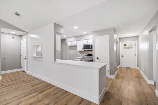 a view of kitchen with stainless steel appliances refrigerator stove and wooden cabinets