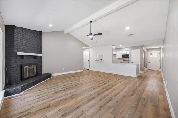a view of empty room with wooden floor and fireplace