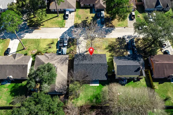 an aerial view of residential houses with outdoor space and trees