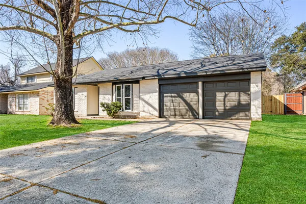 a view of a house with a yard and a large tree