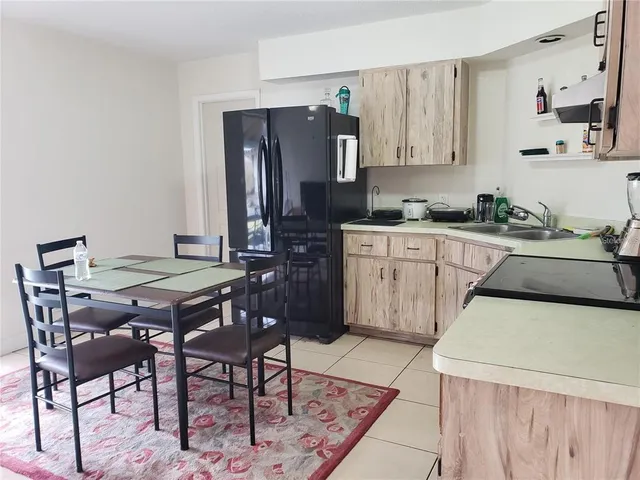 a kitchen with stainless steel appliances kitchen island a table chairs in it and wooden floors