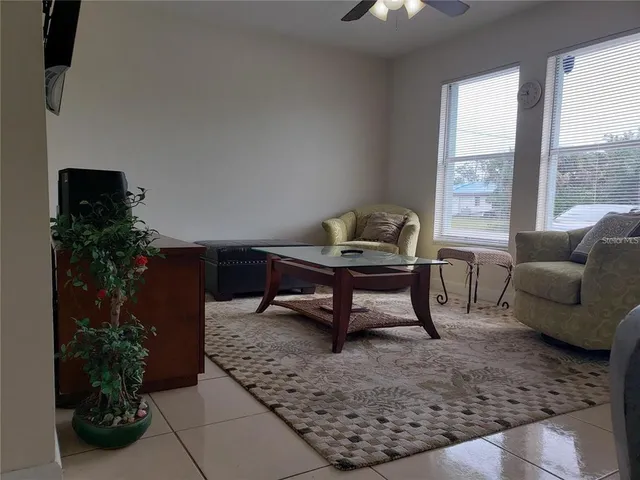 a living room with furniture and a potted plant