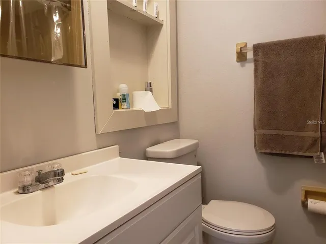 a bathroom with a sink a toilet and mirror