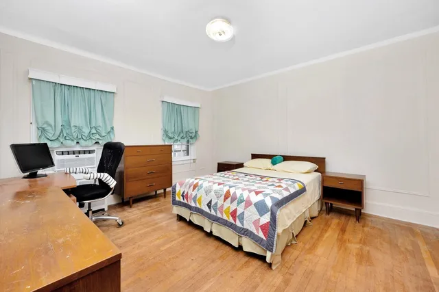 a bedroom with a bed and wooden floor