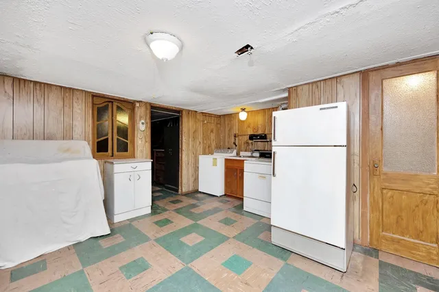 a kitchen with a refrigerator a stove top oven and cabinets