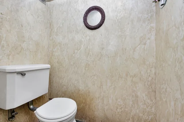 a white toilet sitting next to a white sink and a vanity