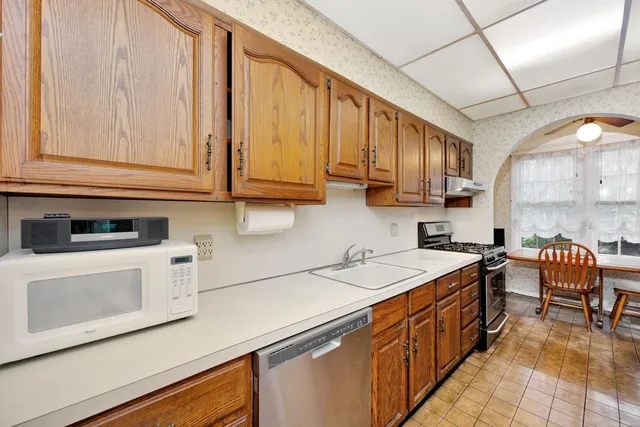 a kitchen with stainless steel appliances granite countertop a sink a stove and cabinets