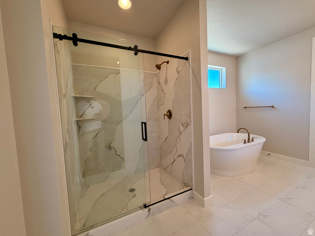 5885 Canyon Rim Road, Unit 624 Lehi, UT 84048 - Photo 11 of 17 Walk-in shower with clear glass enclosure and black hardware, featuring white tiled walls with grey veining and built-in shelving