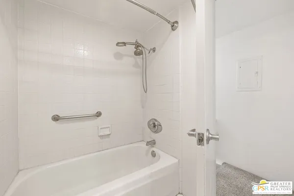 an empty room with fan and shower