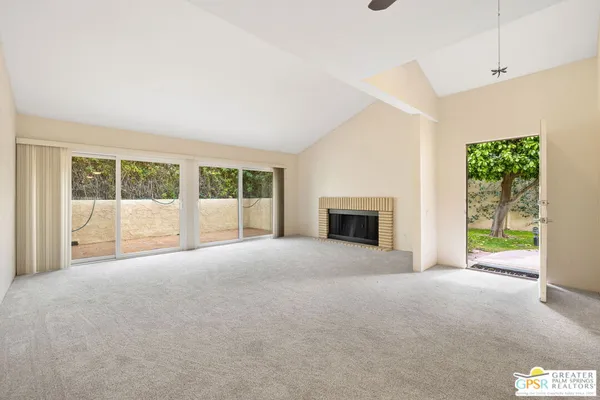 a view of an empty room with a fireplace and a window