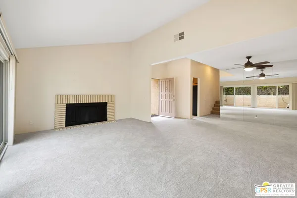 a view of an empty room with a fireplace and a window