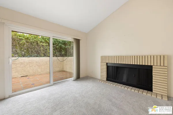 a view of an empty room with a fireplace and a window
