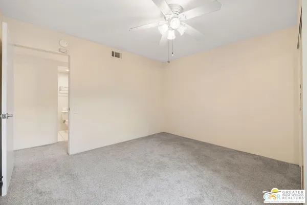 an empty room with a chandelier fan