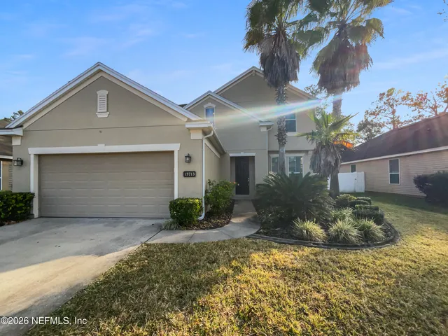a front view of a house with a yard and garage