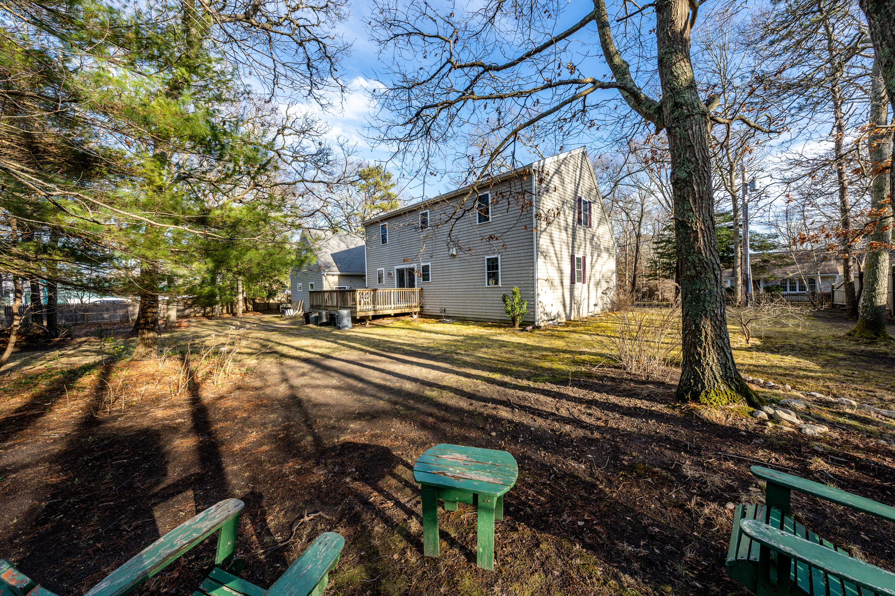 116 Old Post Road Centerville, MA 02632 - Photo 20 of 27 a backyard of a house with large trees and outdoor seating
