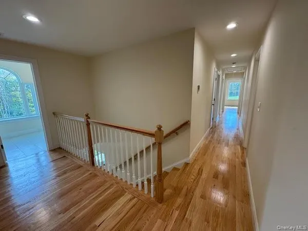 a view of a hallway with wooden floor and staircase