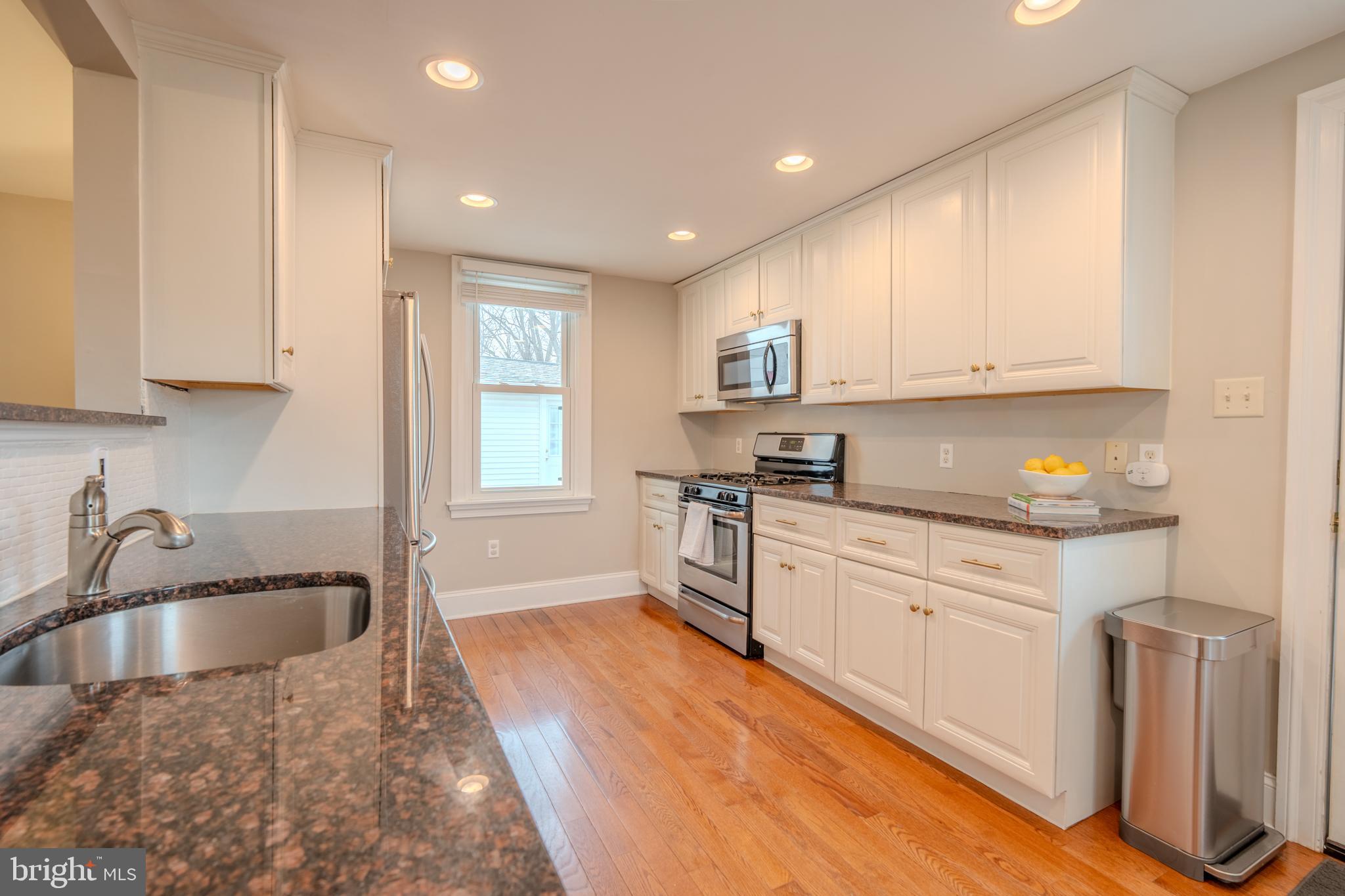 315 West Spring Avenue Ardmore, PA 19003 - Photo 13 of 42 a kitchen with granite countertop a sink white cabinets and stainless steel appliances
