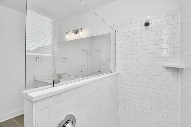 a bathroom with a shower sink and mirror