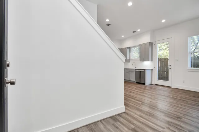 a view of empty room with wooden floor and fireplace
