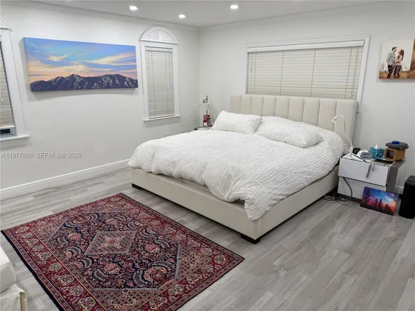 a bedroom with a bed rug and wooden floor