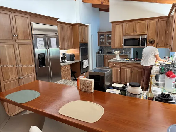 a kitchen with a table chairs stove and refrigerator