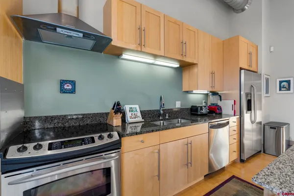 a kitchen with stainless steel appliances granite countertop a stove and a refrigerator