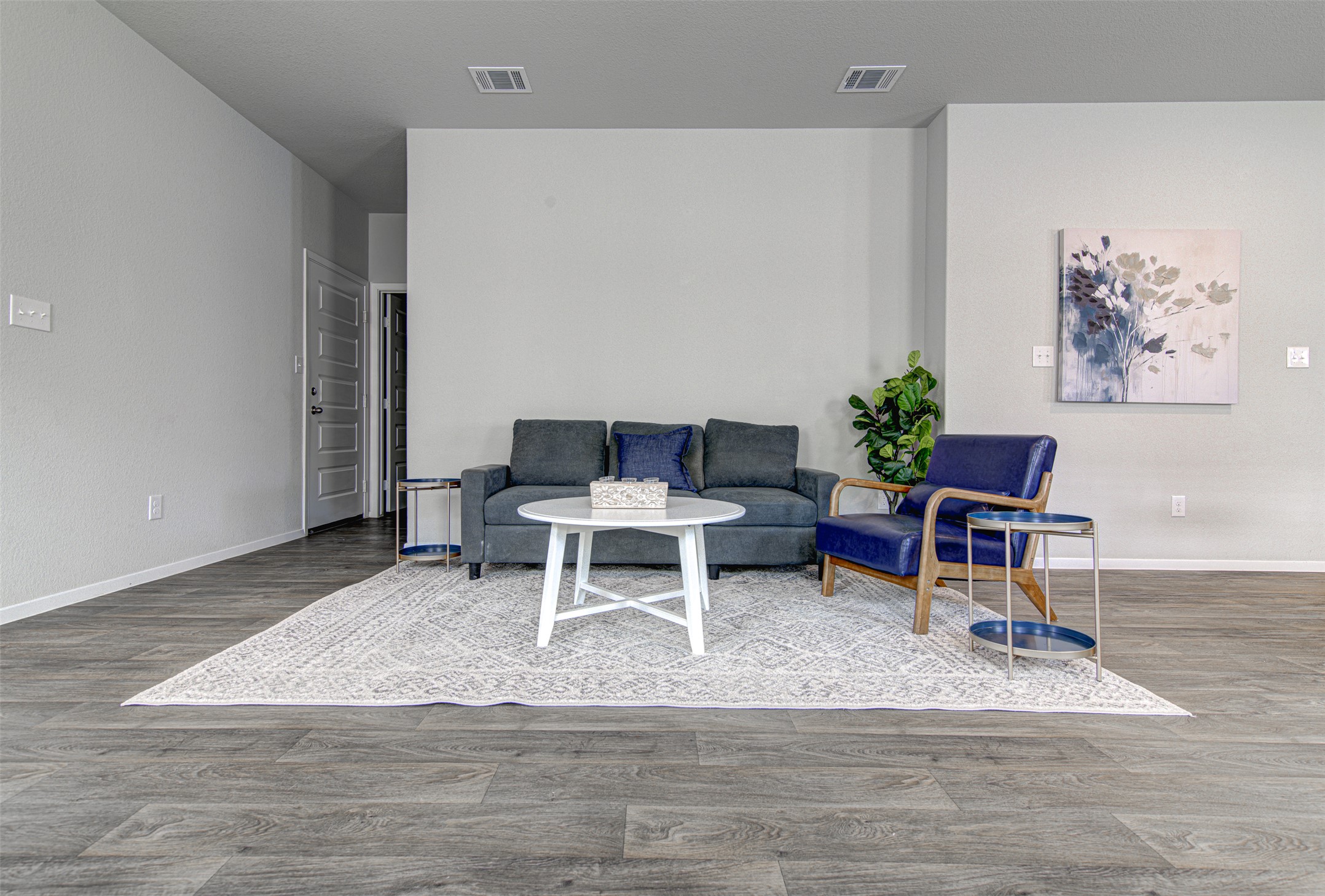 156 Tillage Road Elgin, TX 78621 - Photo 6 of 25 Hardwood-style flooring and a light color palette define this open-concept living area.
