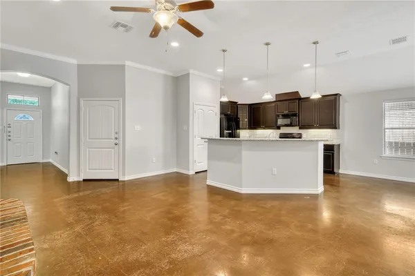 a view of kitchen with kitchen island stainless steel appliances a stove top oven a sink dishwasher and a refrigerator with wooden floor