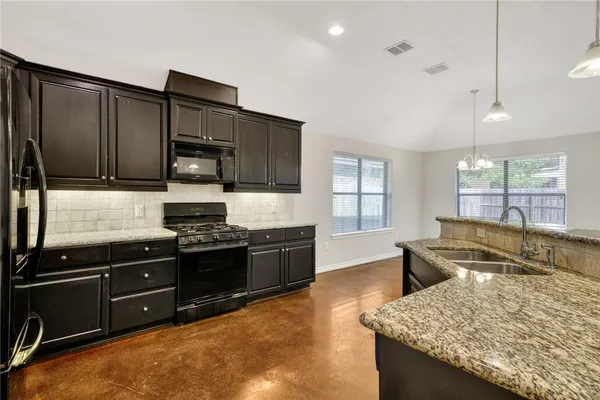 a kitchen with stainless steel appliances granite countertop a sink stove and refrigerator