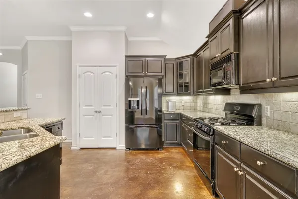 a kitchen with stainless steel appliances granite countertop a refrigerator stove and oven