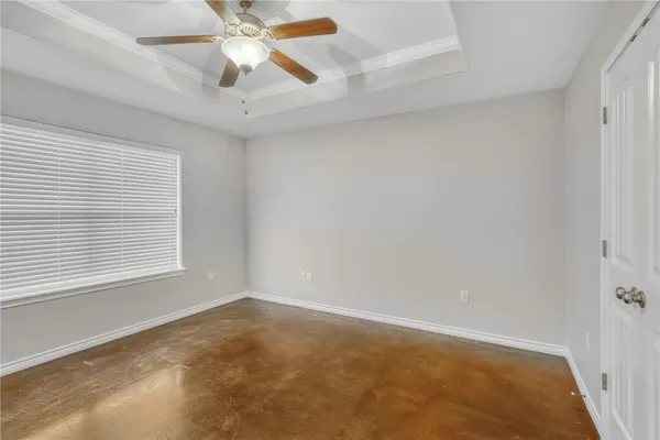 an empty room with a window and a ceiling fan