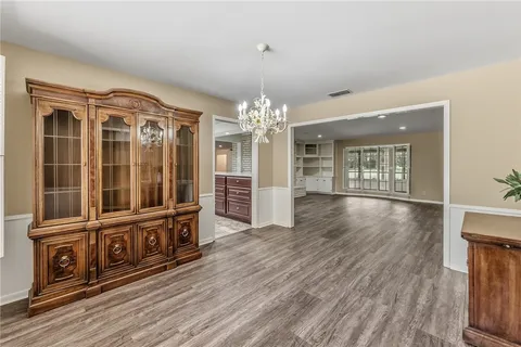 a view of a livingroom with wooden floor and furniture