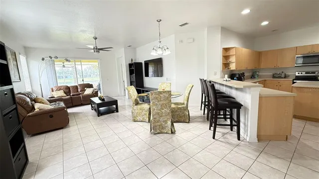 a living room with furniture a flat screen tv and kitchen view