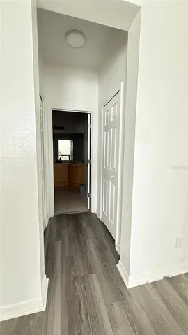 a view of a hallway with wooden floor and a living room
