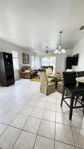 a living room with furniture a flat screen tv and kitchen view