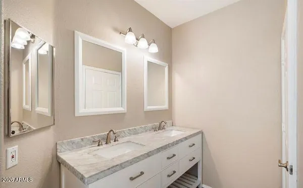 a bathroom with a granite countertop sink a light fixture and a mirror