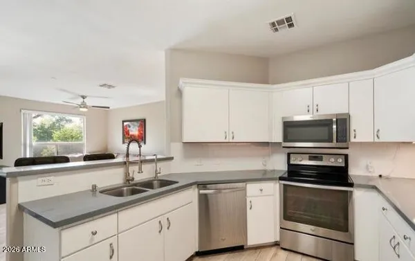 a kitchen with granite countertop a sink and cabinets